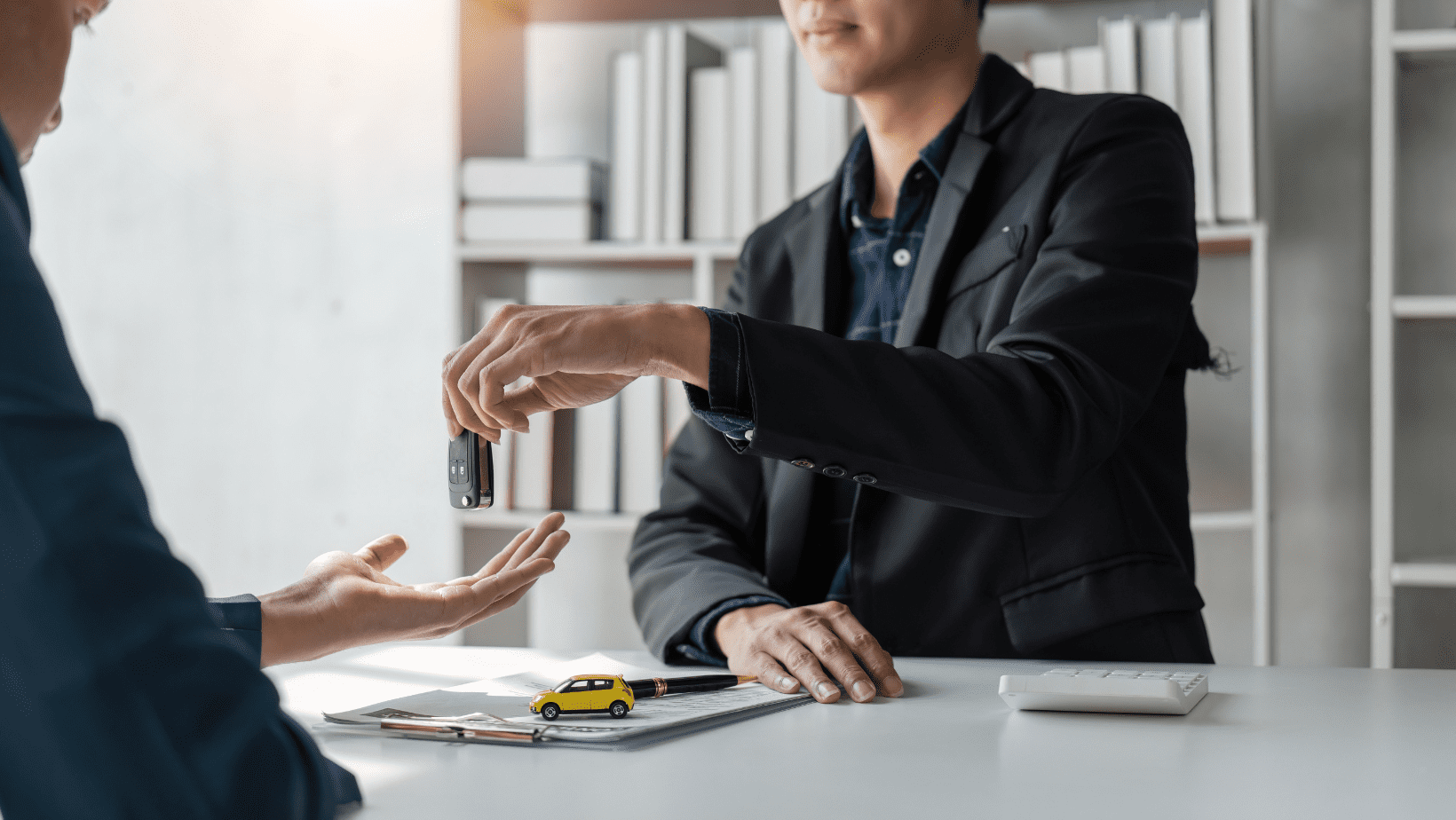Car key being handed over in a professional setting.