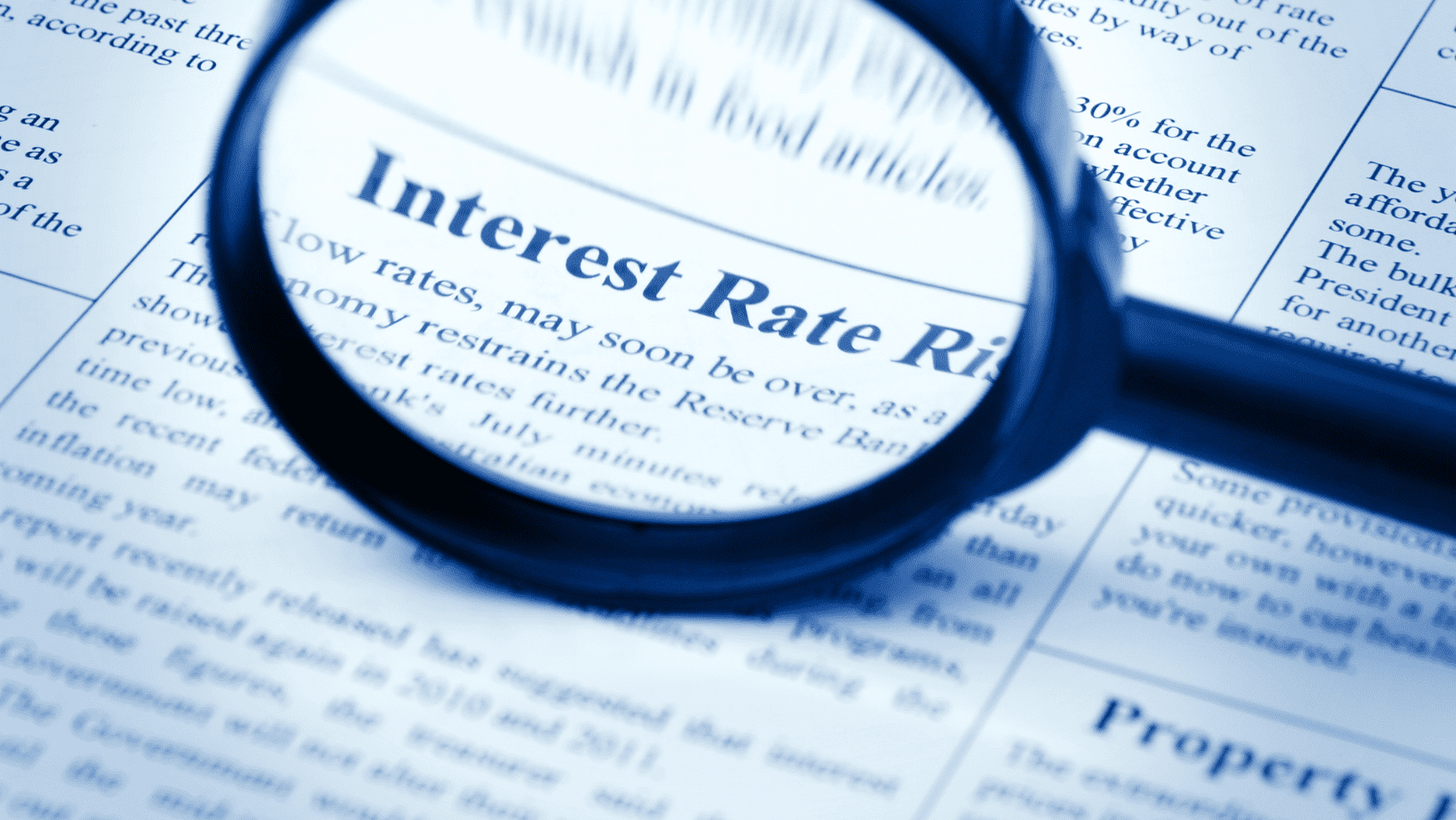 Magnifying glass over a newspaper with interest rate information.