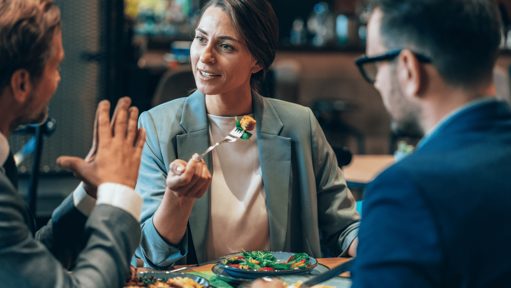 Women and men having a professional conversation during a business lunch.