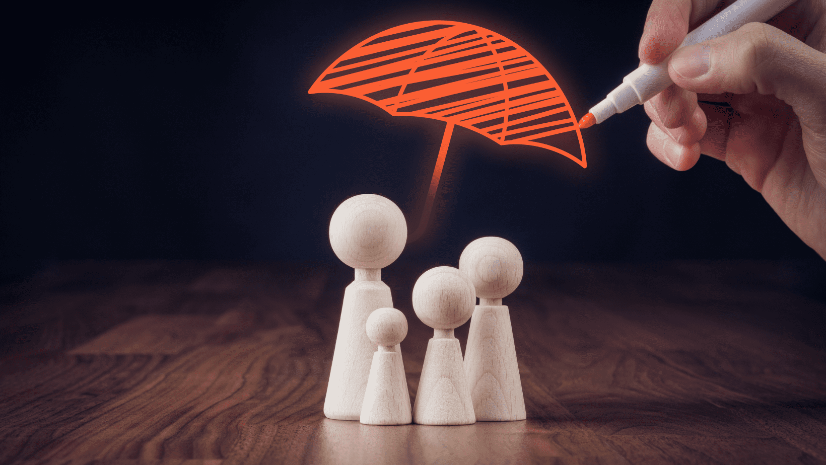 A colorful paper umbrella being drawn over small wooden figurines on a dark background.