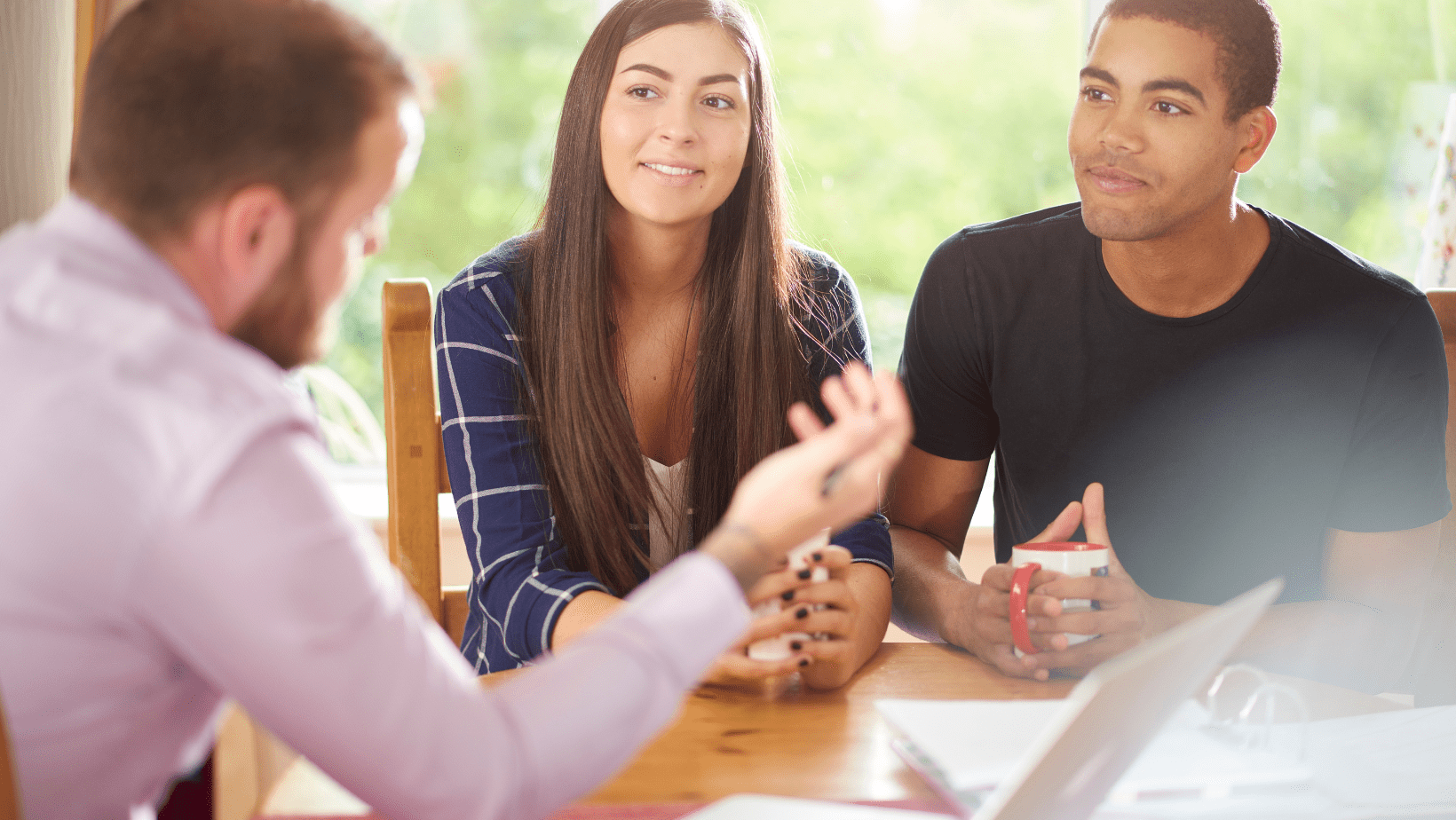 Young adults engaged in a conversation with a counselor at a table.