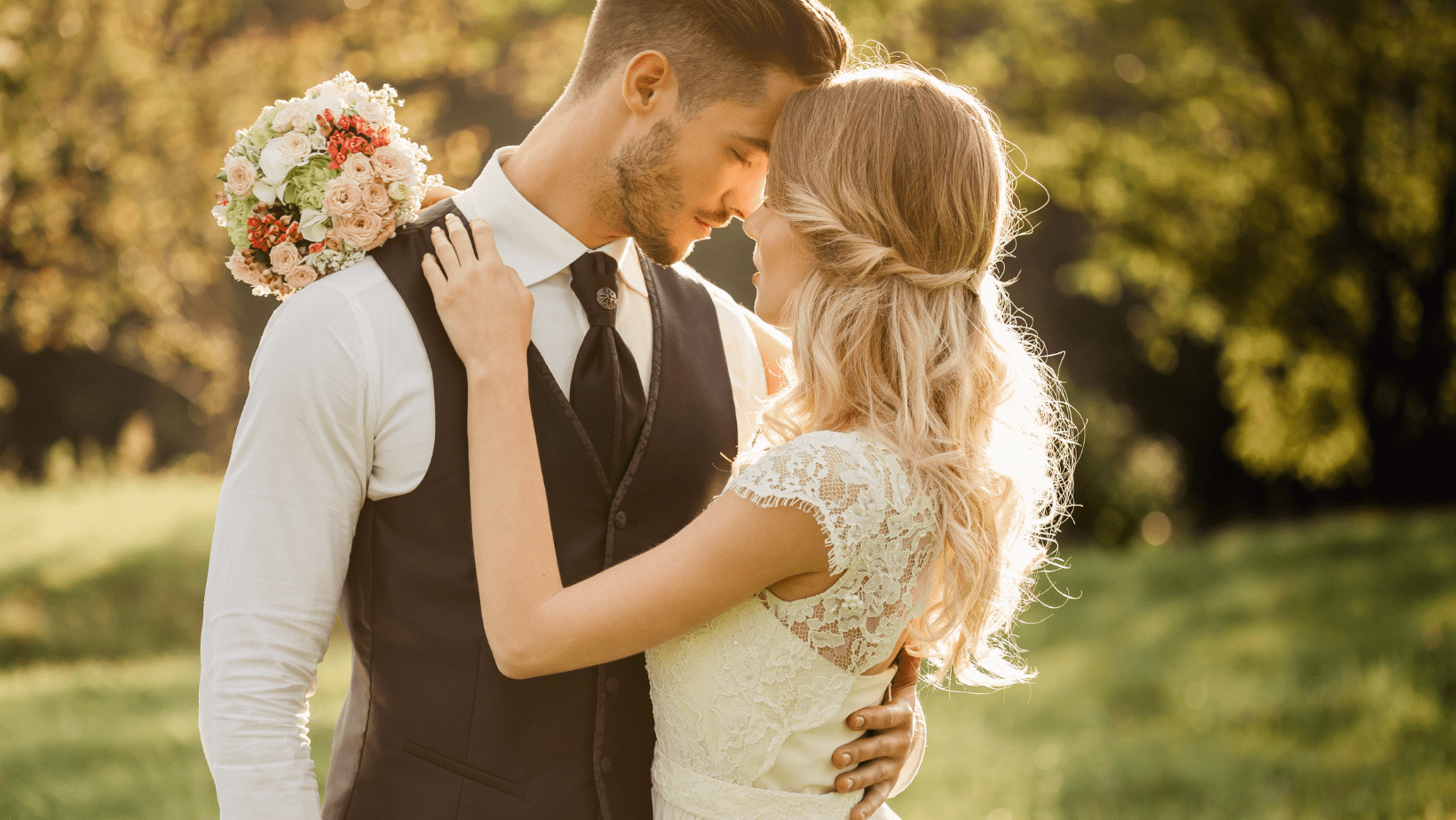 A beautiful bride and groom embracing in a field.