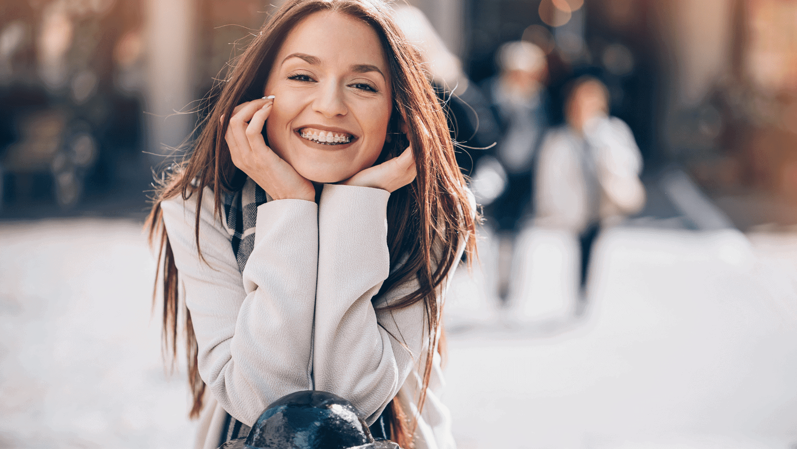 A woman is smiling while sitting on a bench.