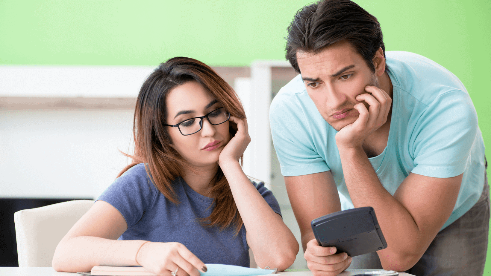 Young couple feeling worried while using a smartphone.