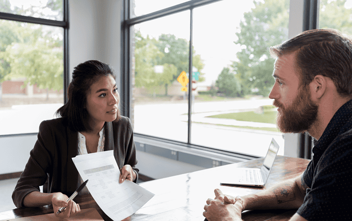 Young woman discussing career options with a male counselor during a professional meeting.