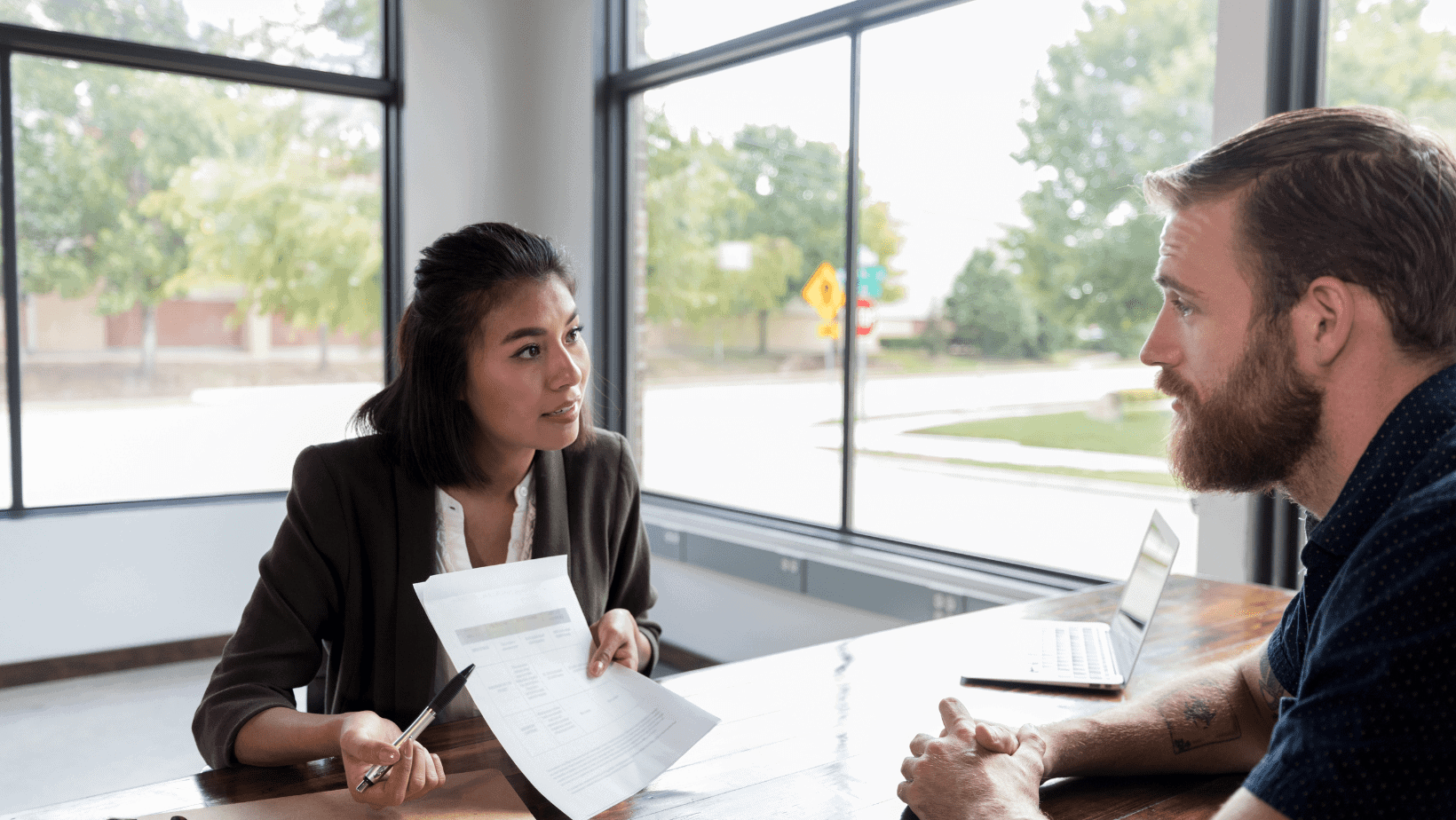 Young woman discussing career options with a male counselor during a professional meeting.