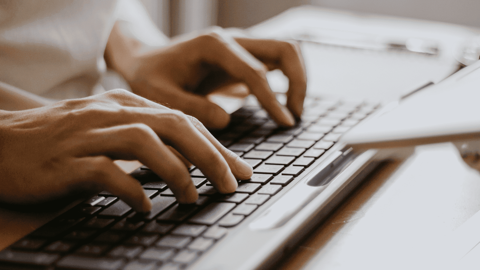 Person typing on a laptop keyboard for work or study.